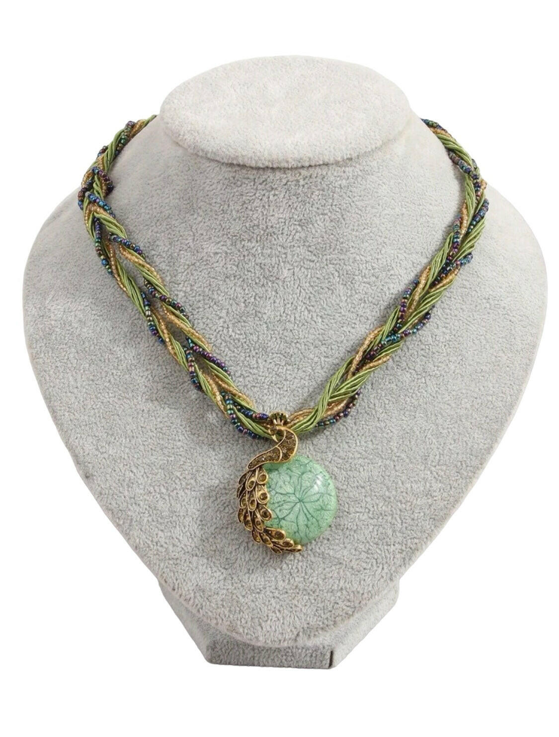 This stunning vintage necklace features a beautiful green peacock-shaped pendant encrusted with shimmering rhinestones. The piece showcases intricate details, adding a touch of elegance and charm to any outfit.