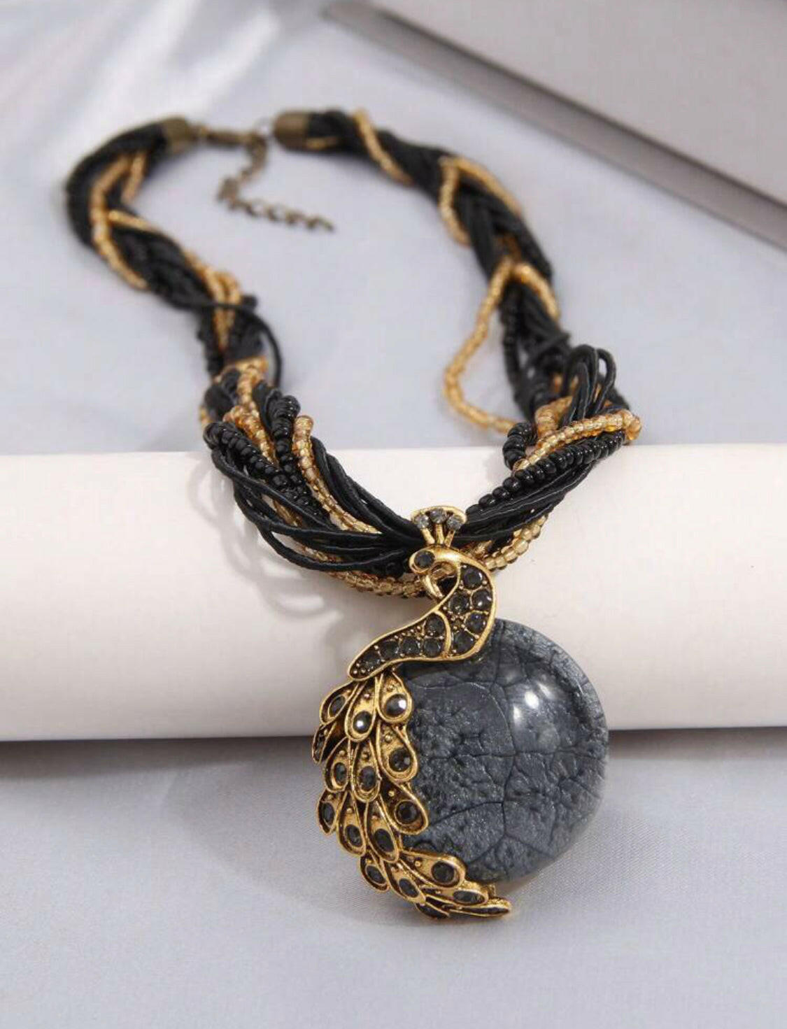 Add a timeless touch of sophistication to your wardrobe with this classic black vintage peacock shaped pendant necklace. Crafted with a stunning rhinestone-encrusted design and an exquisite gold chain, this elegant piece is the perfect accessory for your special occasions.