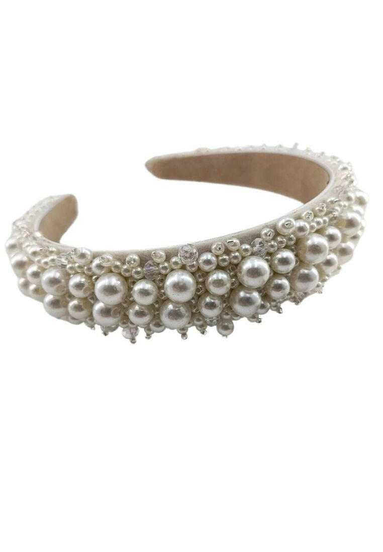Headband adorned with faux pearls, offering a blend of sophistication and fashion for various looks.
