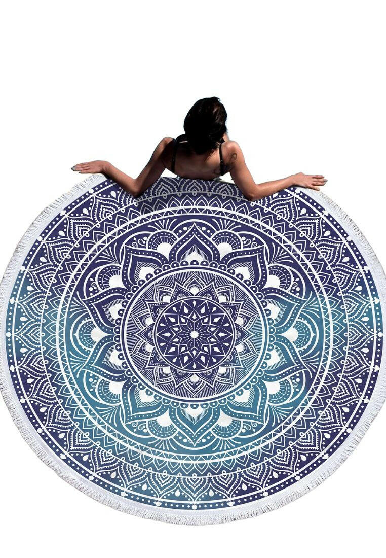 A boho beach towel with a blue ombre mandala print and fringe trim. The towel features a gradient of blue colors in a mandala pattern, with fringe trim along the edges. This towel is stylish and versatile, suitable for beach outings or outdoor relaxation. The blue ombre design and fringe trim add a touch of bohemian flair to the towel.