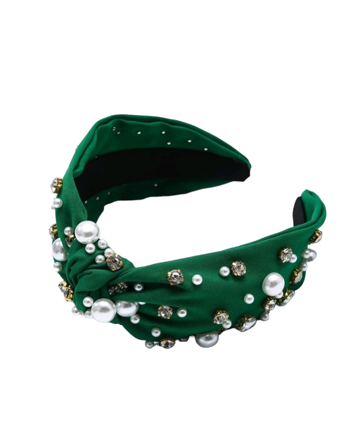 An olive green headband adorned with rhinestones and faux pearls, creating a chic and glamorous accessory. The headband is elegantly displayed, showcasing its intricate embellishments and stylish design.