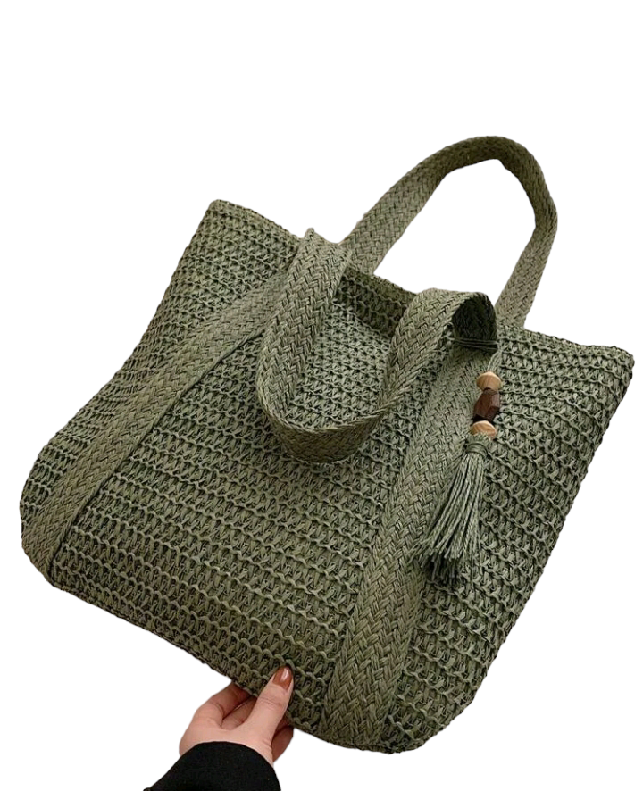 A large capacity straw bag with tassel decor, designed for vacations and leisure. The bag is made of woven straw material and features a spacious interior. It is adorned with decorative tassels for added style. The bag is perfect for carrying your essentials during vacation or outings, adding a touch of boho chic to your look.