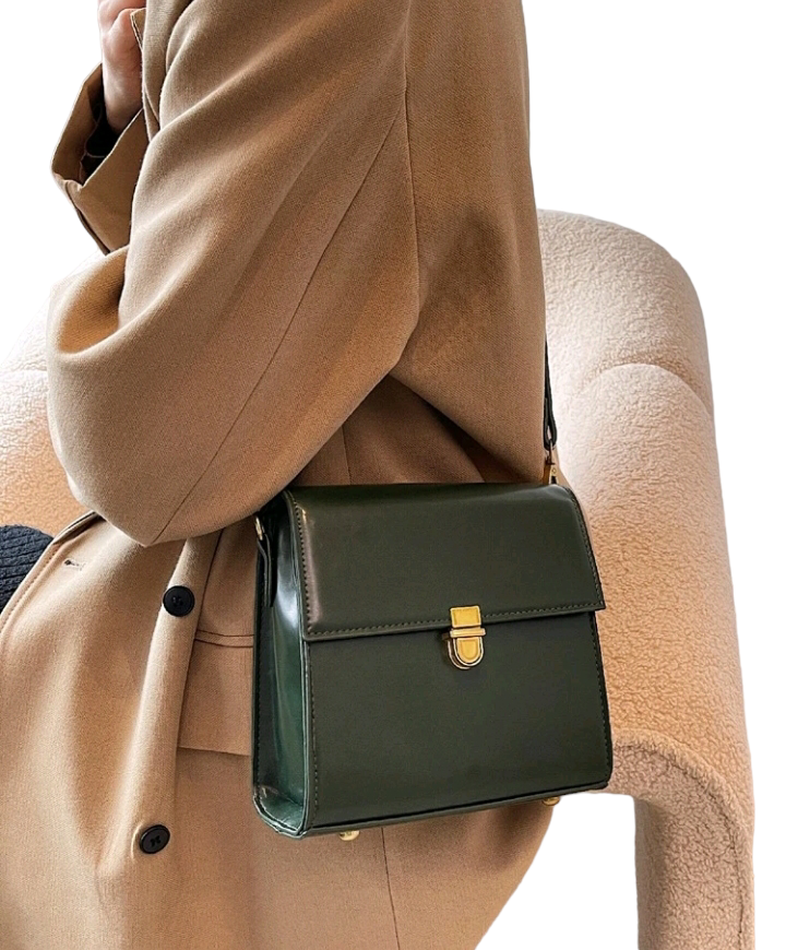 A dark green mini flap square bag with intricate stitch detailing. This compact bag has a square shape with a rich dark green hue. It showcases meticulous stitching on its surface and is designed as a stylish accessory for carrying small items or essentials with flair.
