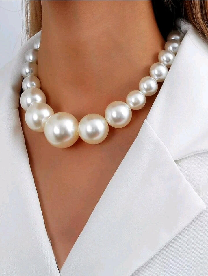 Stunning faux pearl beaded necklace with lustrous, creamy-white spherical beads arranged in a classic and timeless design. The necklace is a graceful and elegant accessory, perfect for adding a touch of sophistication to any outfit.