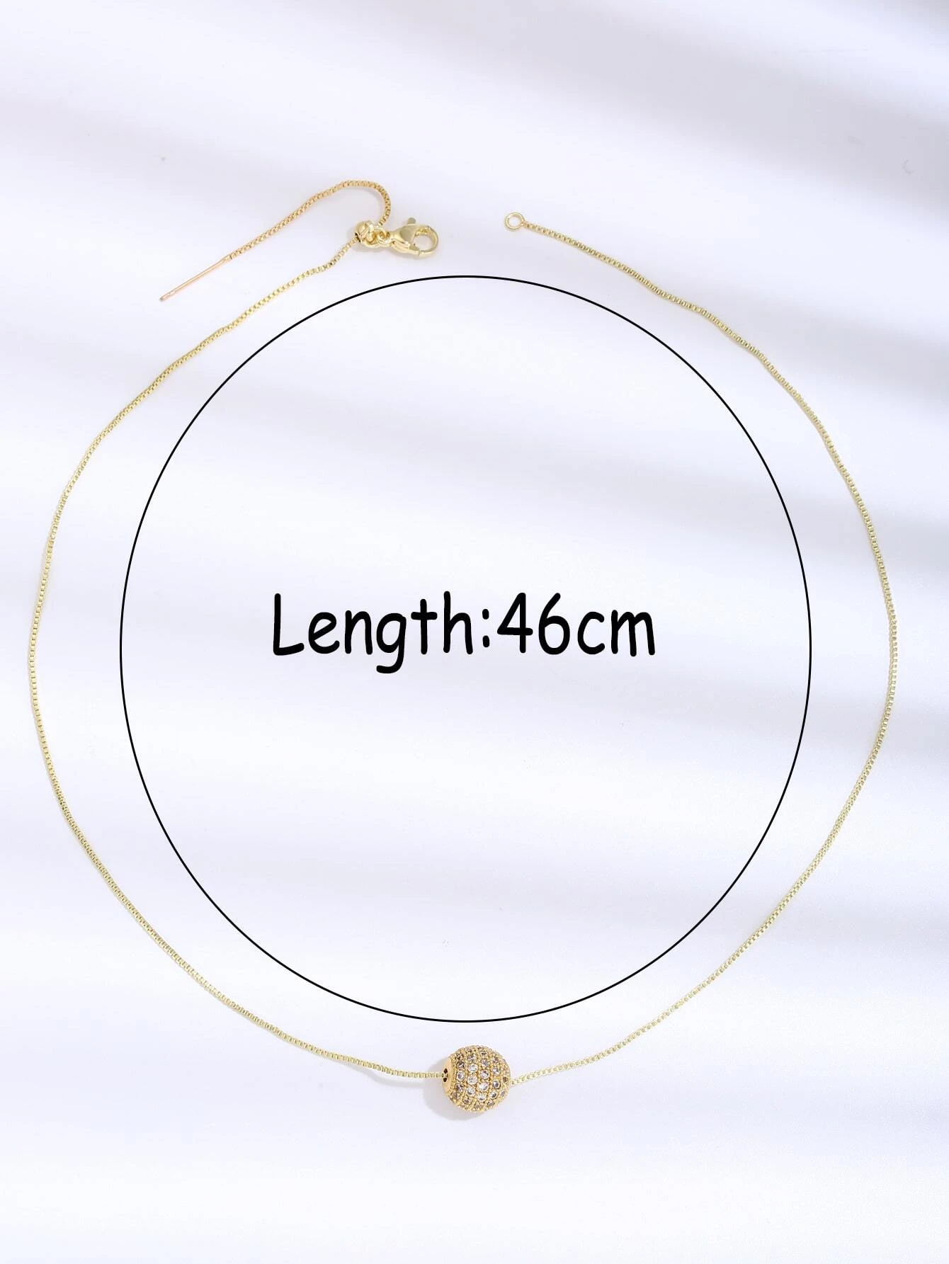 A necklace featuring a cubic zirconia ball charm pendant. The pendant showcases a round charm adorned with cubic zirconia gemstones, suspended from a delicate chain. This necklace is both elegant and versatile, adding a touch of glamour and sparkle to different outfits.