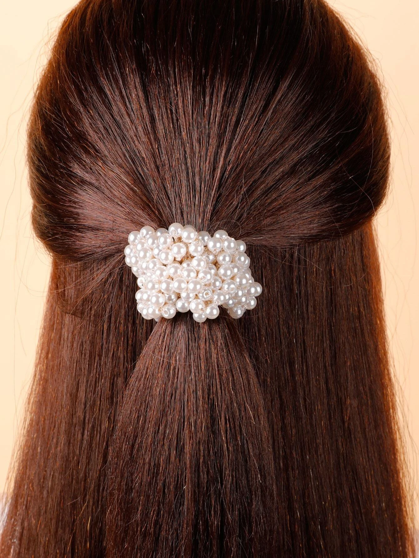 A single hair tie adorned with faux pearls, offering a stylish and elegant way to accessorize and enhance your hairstyle.