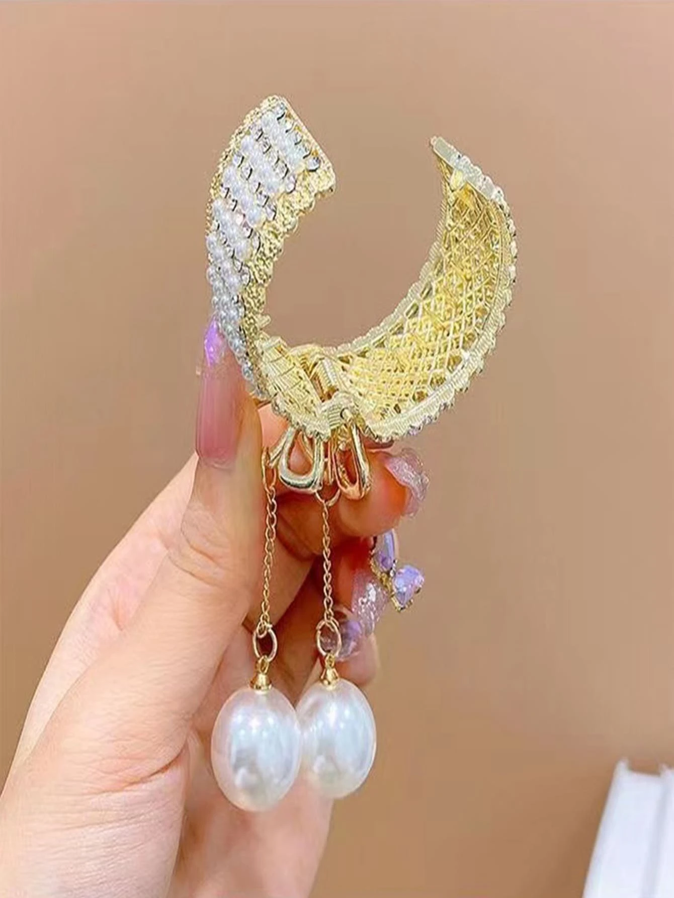 Hair claw adorned with rhinestones and faux pearls, offering a chic and stylish way to secure your hair.