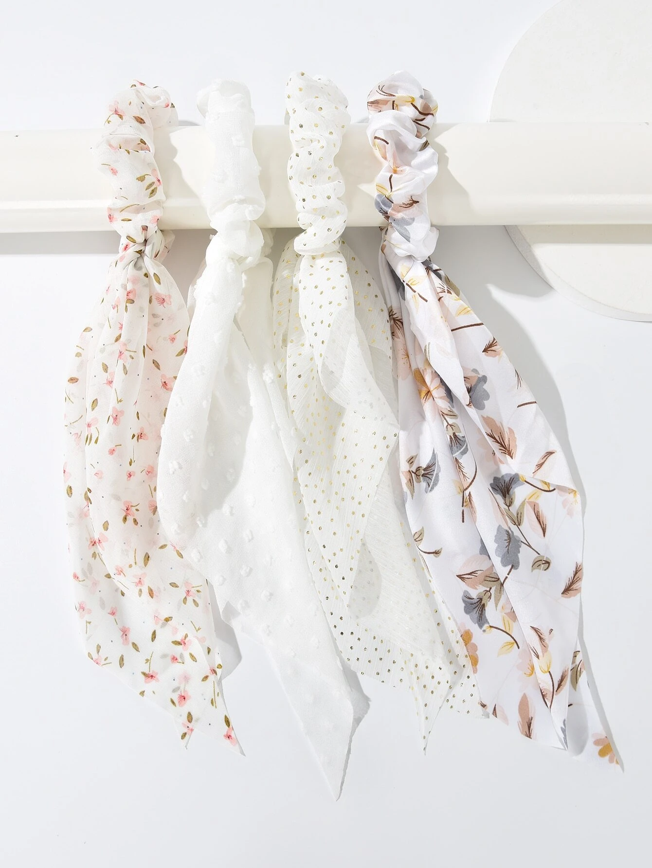 A set of four hair ties featuring floral print designs, adding a touch of nature-inspired charm to your hair accessories.