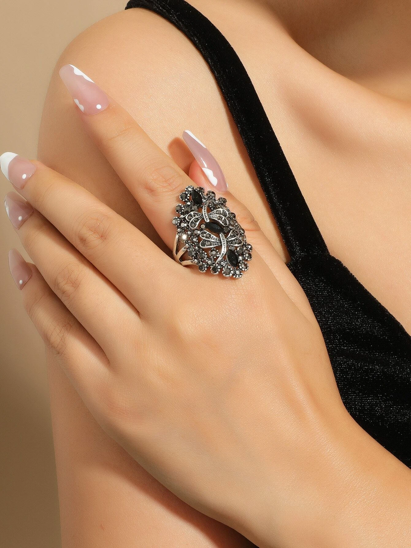 An exquisite dragonfly-themed ring adorned with rhinestones. The ring showcases a detailed dragonfly motif crafted with shimmering rhinestones, creating a captivating and whimsical look. The combination of the intricate design and the sparkling gems adds an element of elegance and charm to this accessory. A fashionable and unique piece of jewelry that can elevate various outfits.