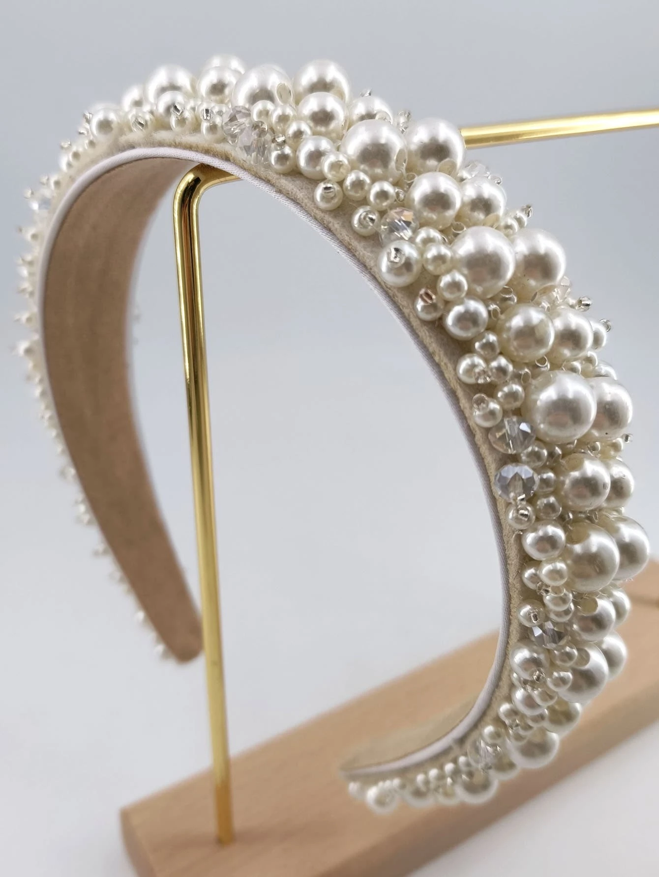 Headband adorned with faux pearls, offering a blend of sophistication and fashion for various looks.
