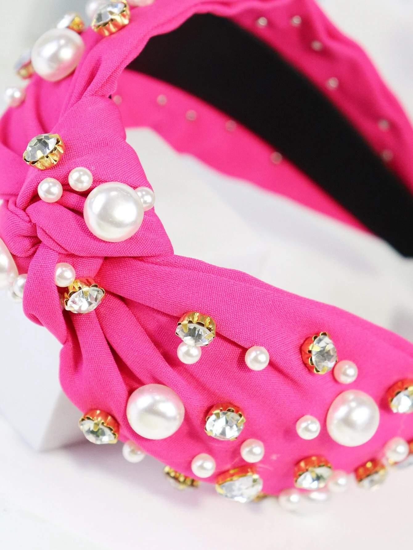 Vibrant headband featuring hot pink rhinestones and faux pearls for a stylish and eye-catching accessory.