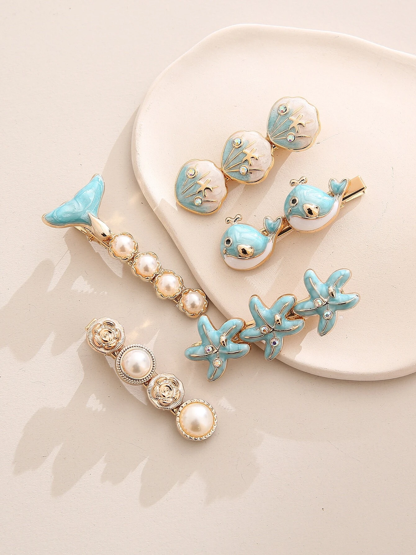 A set of five boho hair clips featuring starfish and shell decorations, adding a beachy and whimsical touch to your hair styling.