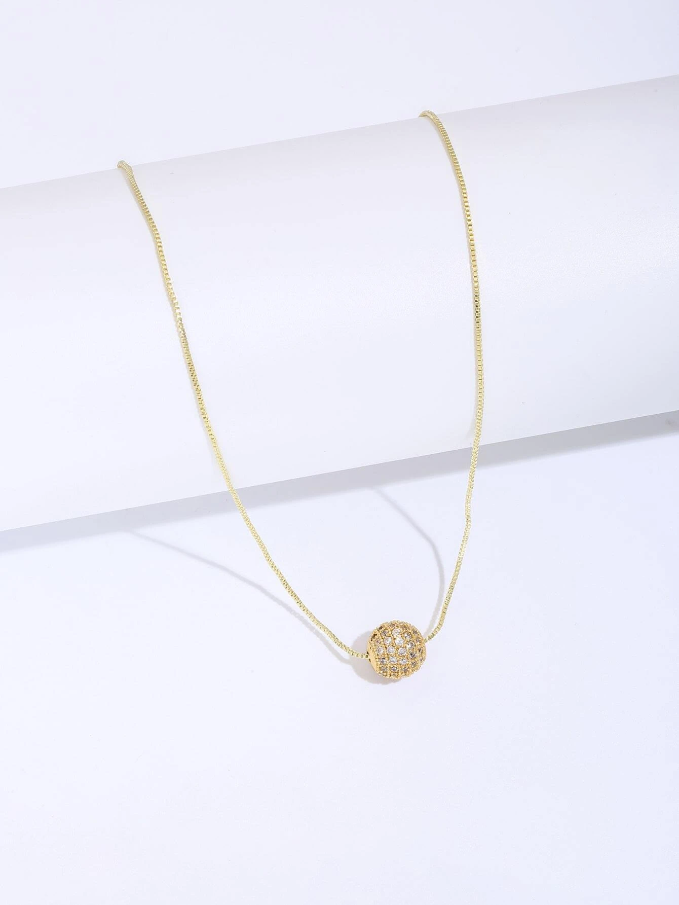 A necklace featuring a cubic zirconia ball charm pendant. The pendant showcases a round charm adorned with cubic zirconia gemstones, suspended from a delicate chain. This necklace is both elegant and versatile, adding a touch of glamour and sparkle to different outfits.