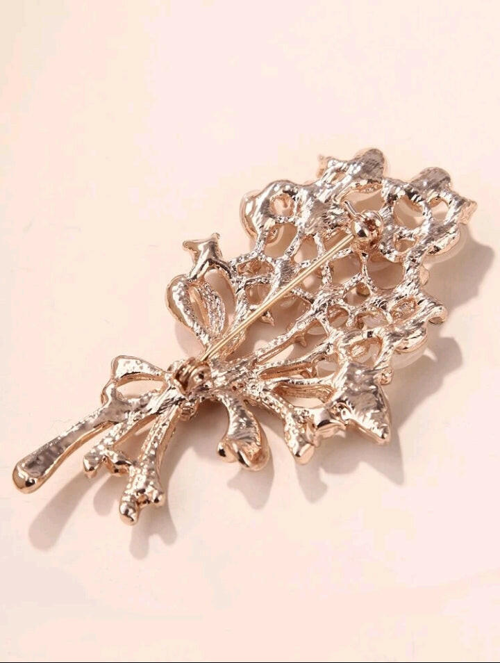 Brooch adorned with intricate rhinestone details, featuring a graceful rose design that adds a touch of elegance and sophistication to your ensemble.