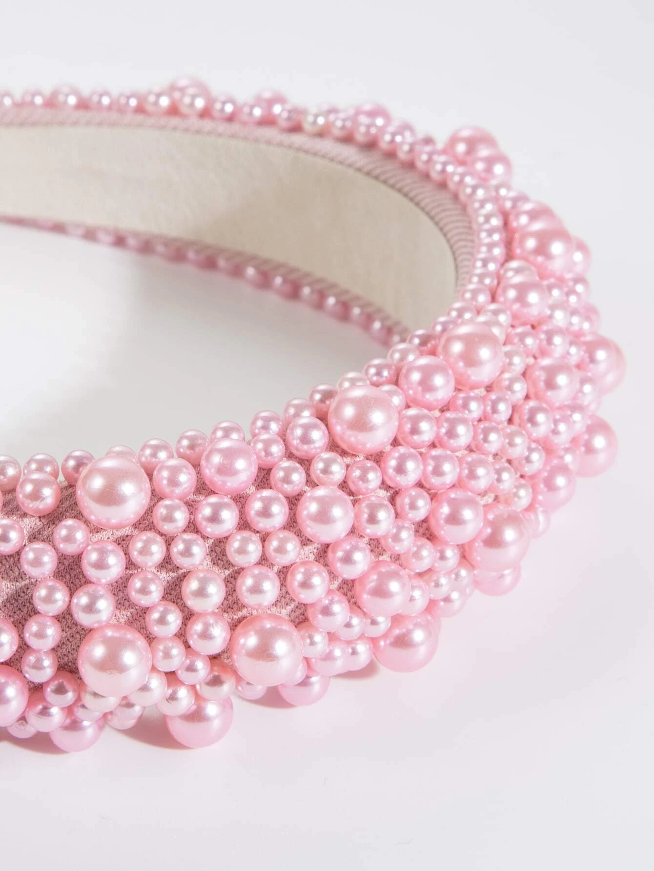 Wide headband adorned with faux pink pearls, offering a blend of style and sophistication, perfect for enhancing your hair ensemble.