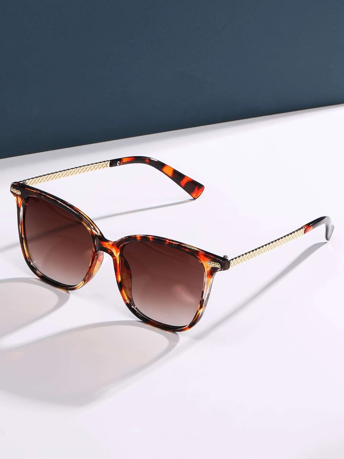 Stylish tortoiseshell frame sunglasses featuring a mottled pattern of rich browns and ambers. The oversized round lenses provide UV protection and a touch of vintage flair, while the sturdy frame design ensures both comfort and durability.