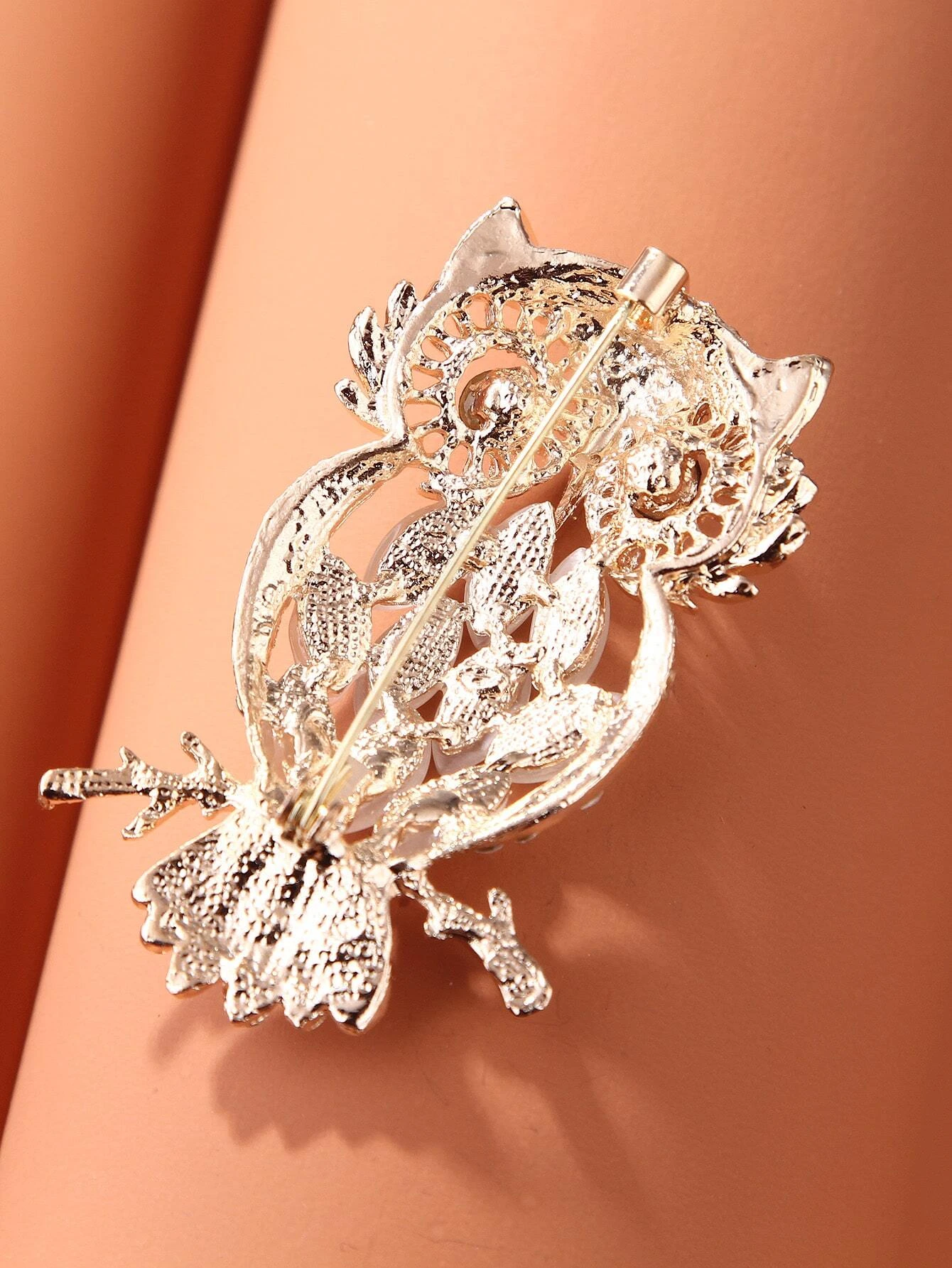 Brooch showcasing a detailed owl design, adorned with shimmering rhinestones, capturing the wisdom and allure of these majestic creatures in a glamorous and enchanting accessory.