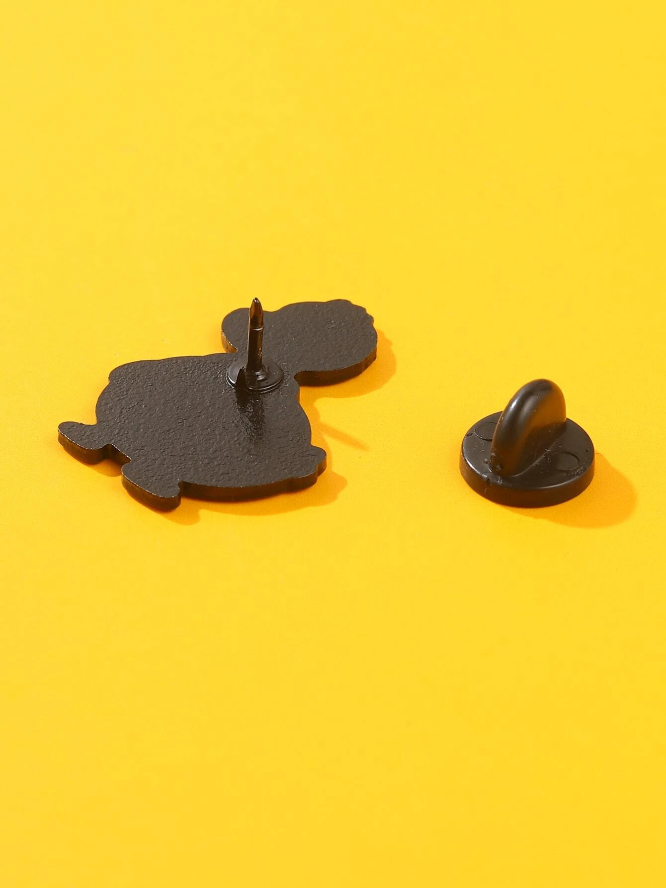 Colorful cartoon duck brooch with a cheerful expression, vibrant yellow feathers, an orange beak, and large, expressive eyes. The brooch is intricately designed, capturing the playful nature of a duck in a whimsical and artistic style.