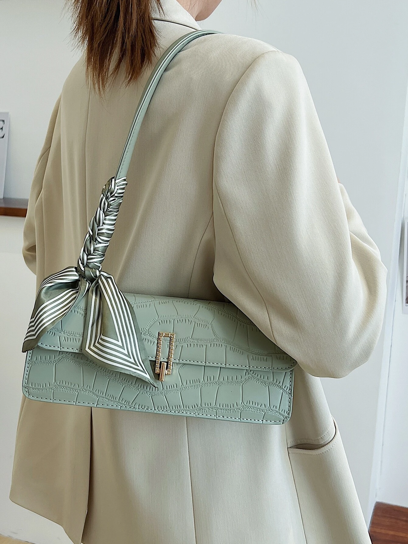 Crocodile embossed flap square bag with twilly decoration. This accessory blends sophisticated texture with stylish embellishments, offering a chic and visually appealing way to carry your essentials.