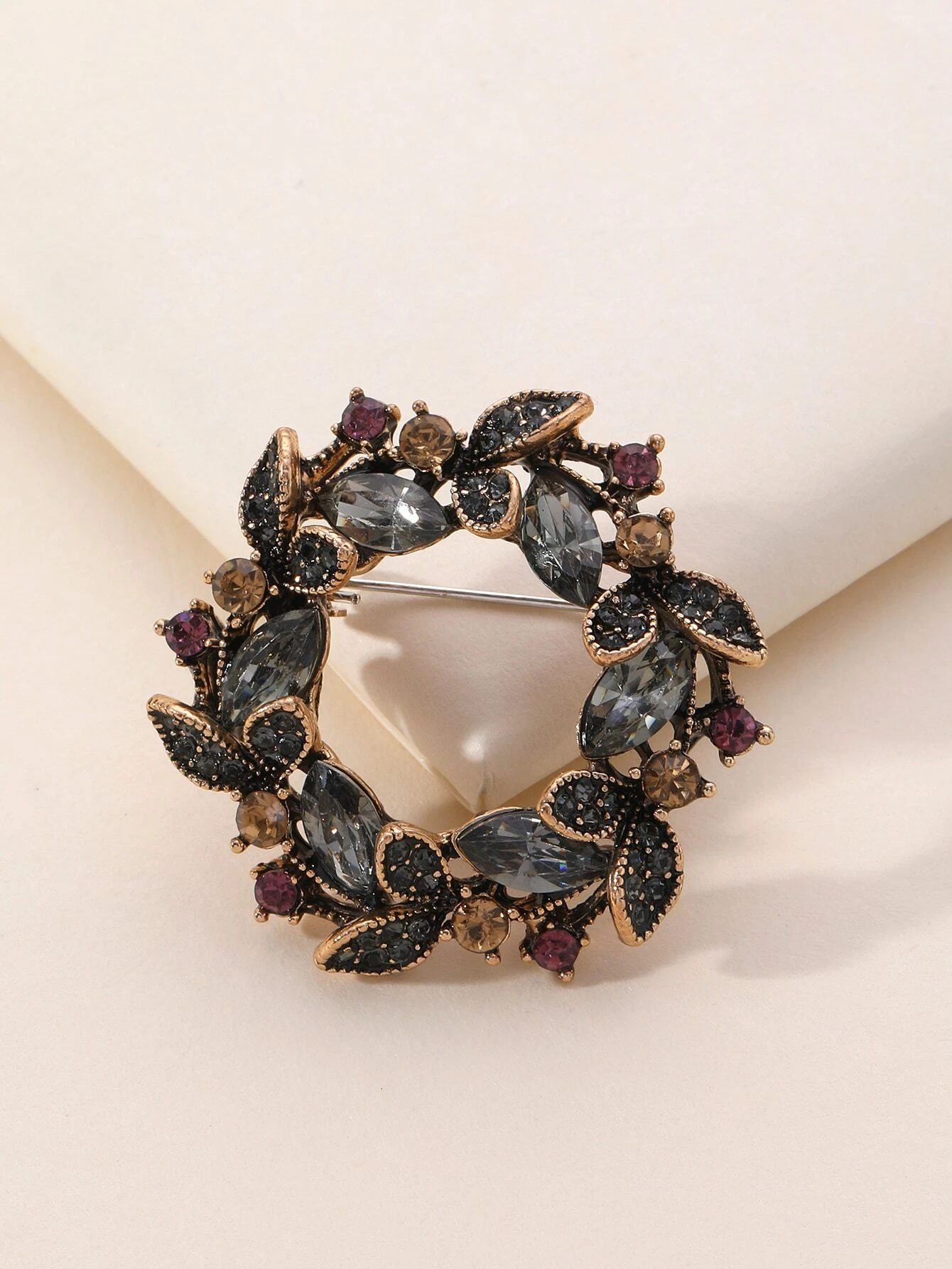 Elegant brooch adorned with rhinestone decorations, enhancing your ensemble with a touch of shimmering and timeless glamour.