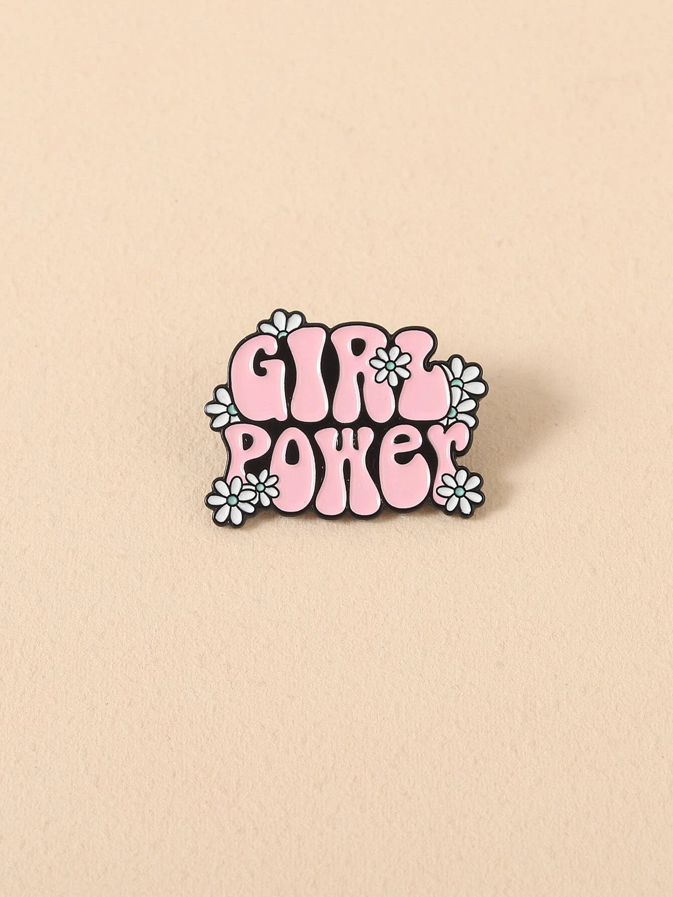 Brooch combining floral motifs and decorative letters, creating a harmonious and stylish accessory with a touch of personalized charm.