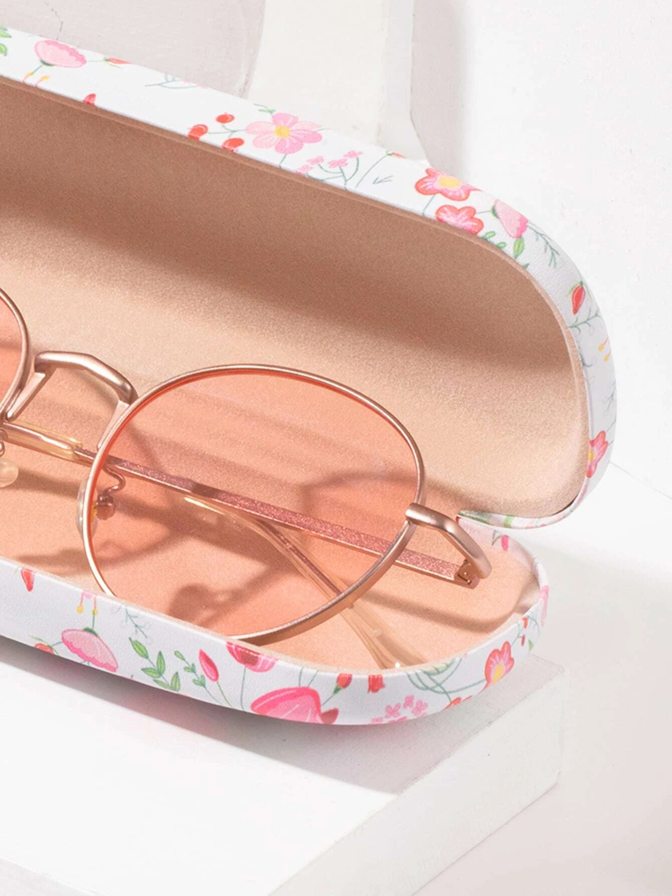 A glasses case featuring a floral print design. The case is designed to store and protect eyeglasses, sunglasses, or other optical frames. The floral print adds a touch of elegance and style to the case. This accessory is both functional and fashionable, offering a secure and stylish storage solution for eyewear.