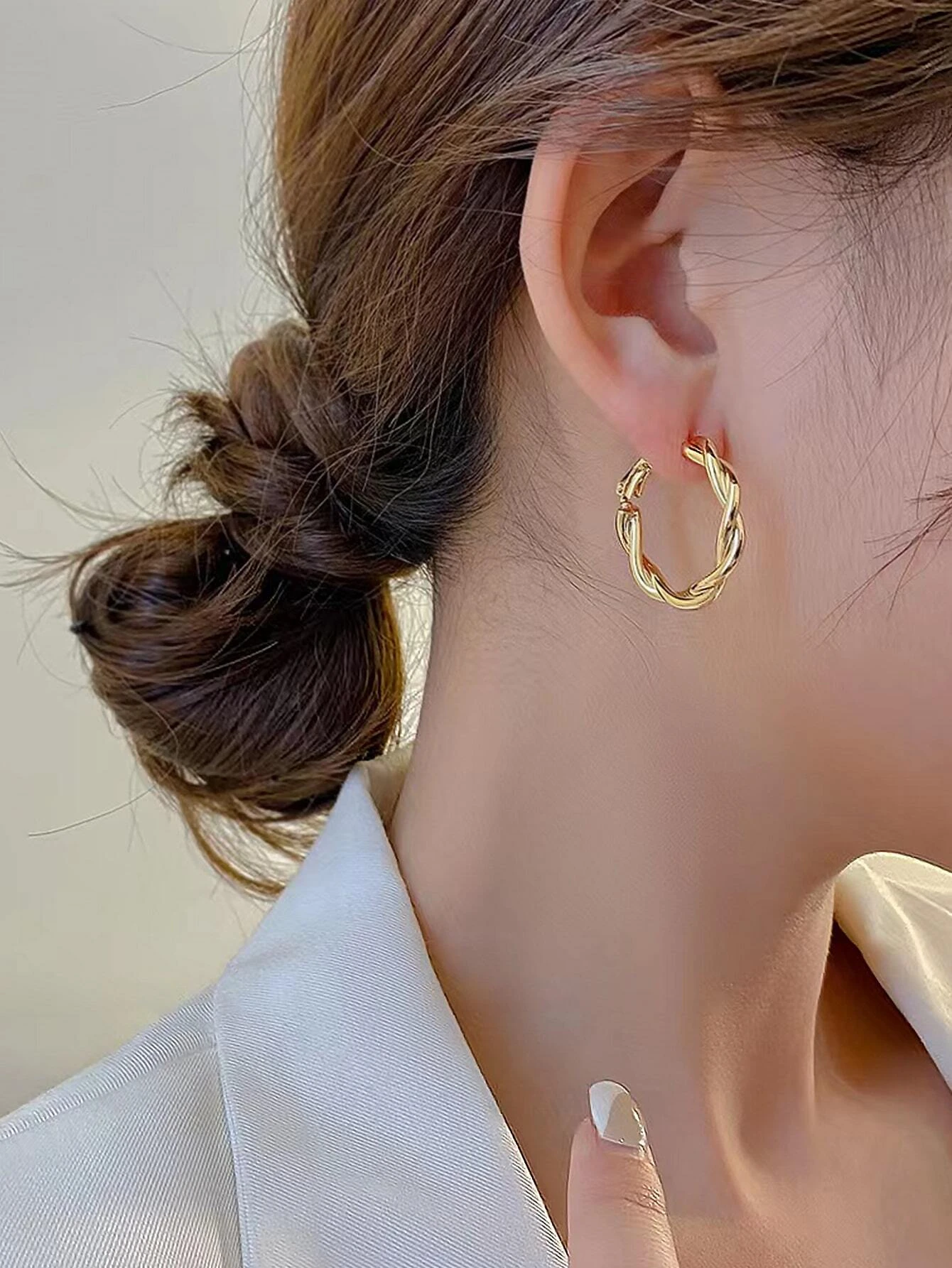 Hoop earrings with a stylish twist design, offering a contemporary and unique accessory.