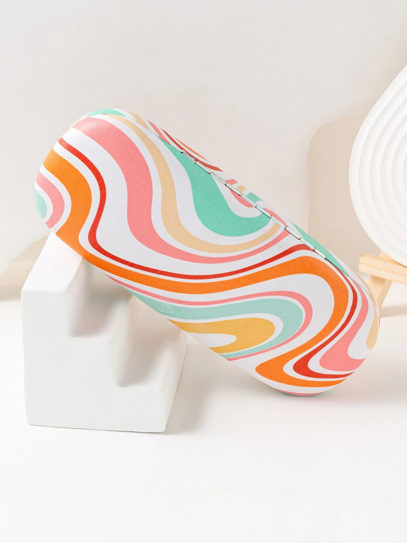 A glasses case with a color block print design. The case is designed to store and protect eyeglasses, sunglasses, or other optical frames. The color block pattern adds a modern and stylish touch to the case. This accessory is both functional and fashionable, offering a secure and trendy storage solution for eyewear.