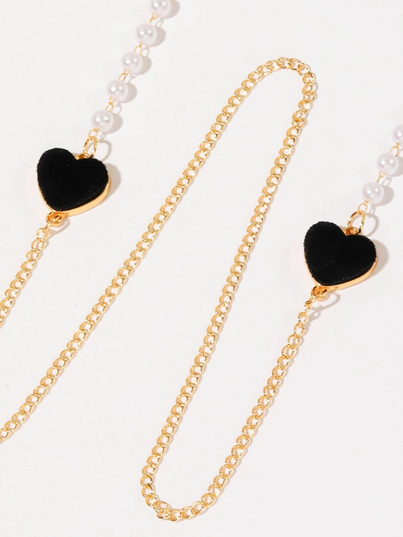 Heart and faux pearl decorated glasses chain, a chic and functional accessory for keeping eyeglasses or sunglasses secure, with a touch of elegance and charm.