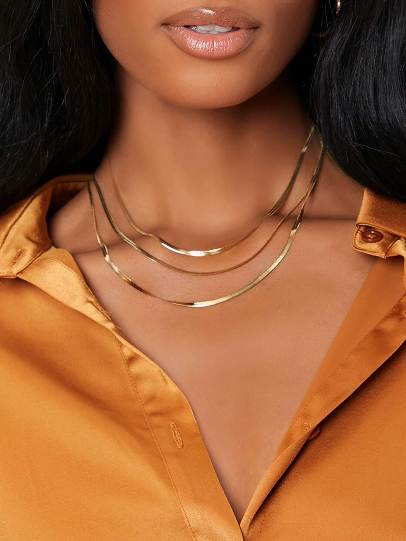 A layered necklace with a minimalist design. The necklace features delicate chains arranged in layers, creating a simple and elegant look. This accessory is modern and versatile, adding a touch of understated sophistication to various outfits