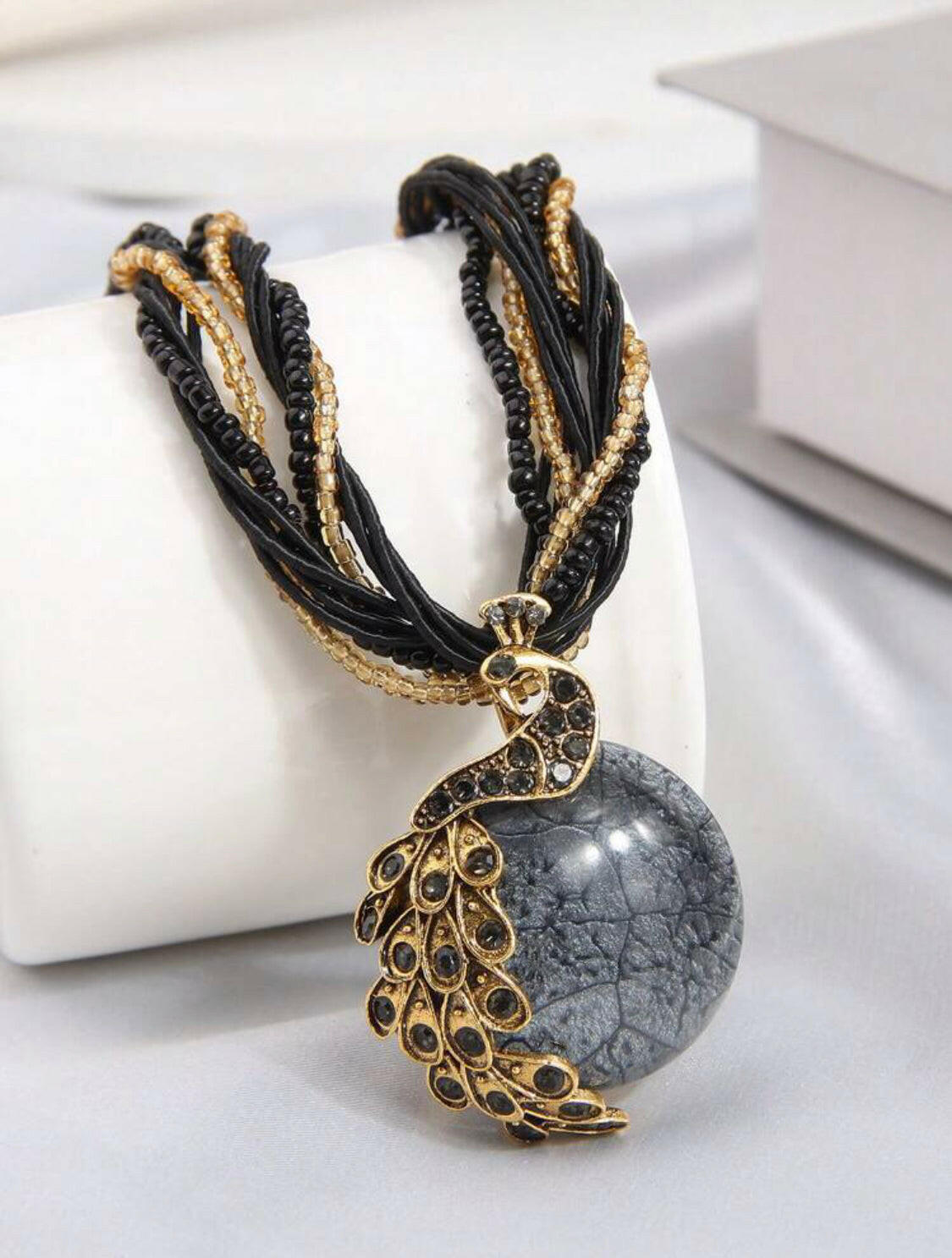 Add a timeless touch of sophistication to your wardrobe with this classic black vintage peacock shaped pendant necklace. Crafted with a stunning rhinestone-encrusted design and an exquisite gold chain, this elegant piece is the perfect accessory for your special occasions.