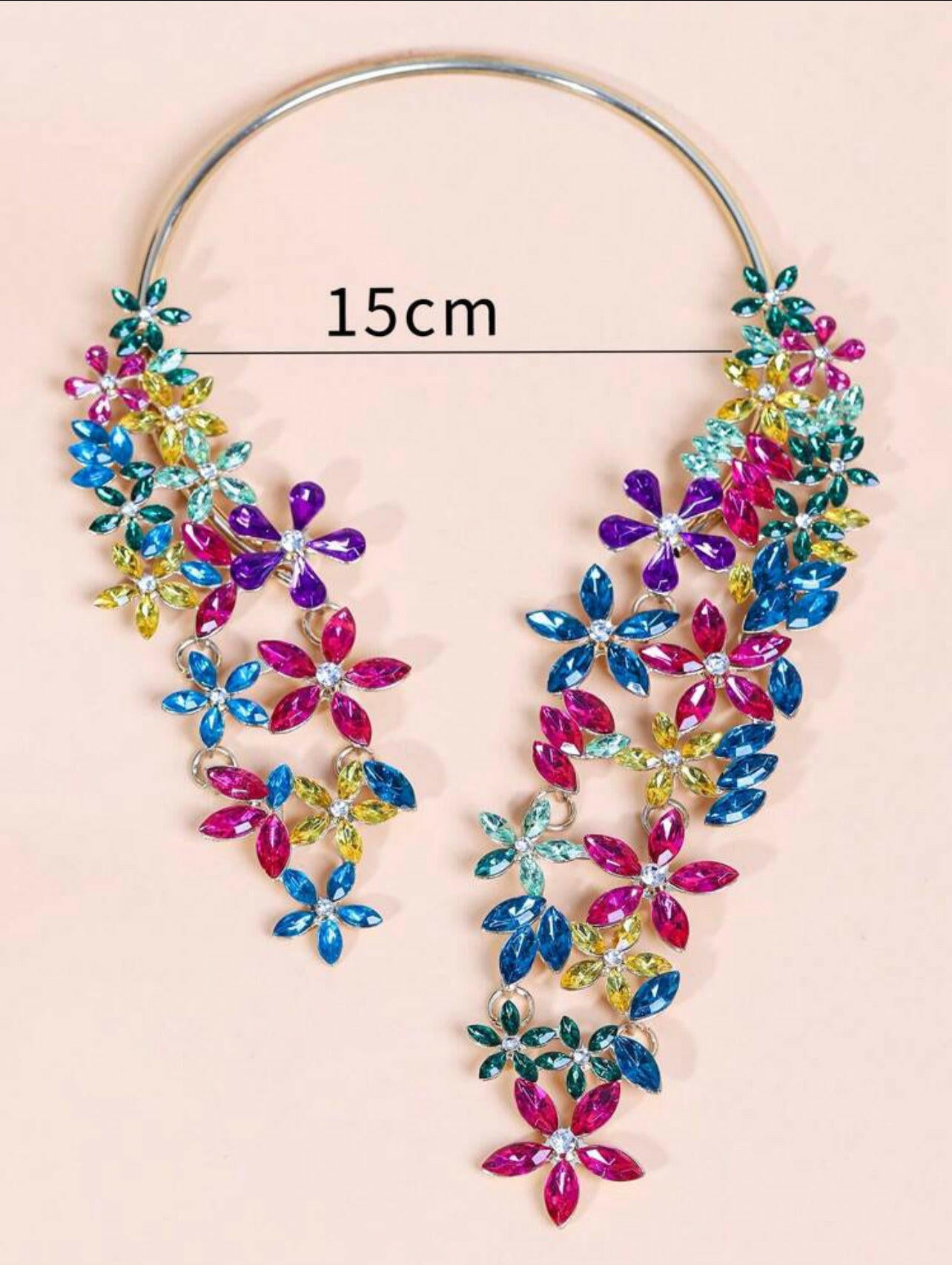 This Rhinestone Flower Decor Necklace is a stunning piece of jewelry that adds a touch of elegance to any outfit. The intricate rhinestone flower design is sure to catch the eye and make a statement. Hand-crafted with care, this necklace is a perfect accessory for any occasion.