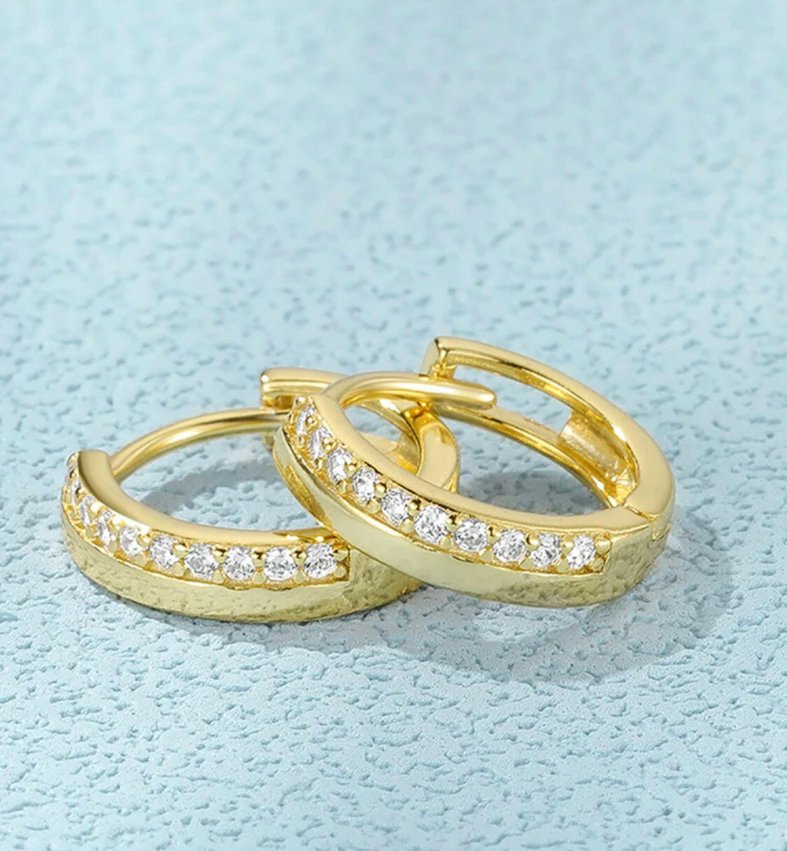 These S925 Sterling Silver Half Pave Cubic Zirconia Earrings feature a luxurious half-pave design, with sparkling cubic zirconia stones. The durable sterling silver setting ensures a long-lasting shine. Perfect for formal or everyday wear!