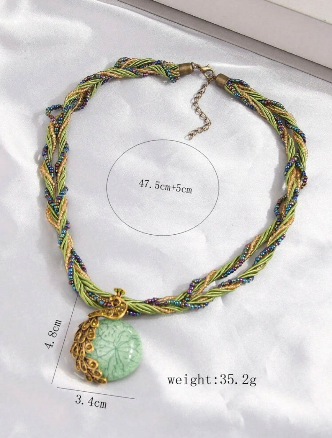 This stunning vintage necklace features a beautiful green peacock-shaped pendant encrusted with shimmering rhinestones. The piece showcases intricate details, adding a touch of elegance and charm to any outfit.