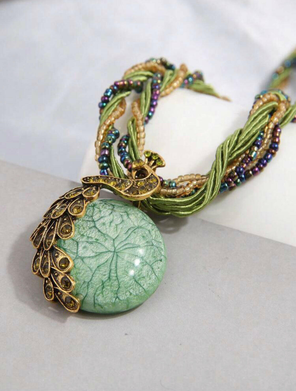This stunning vintage necklace features a beautiful green peacock-shaped pendant encrusted with shimmering rhinestones. The piece showcases intricate details, adding a touch of elegance and charm to any outfit.