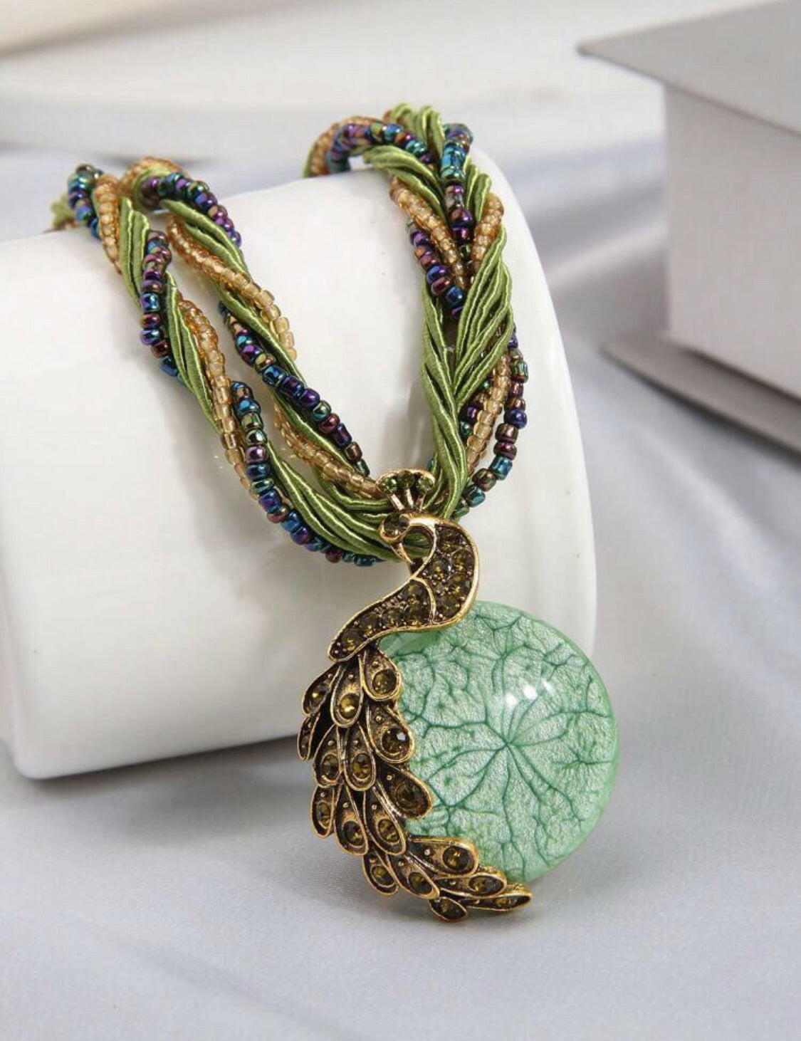 This stunning vintage necklace features a beautiful green peacock-shaped pendant encrusted with shimmering rhinestones. The piece showcases intricate details, adding a touch of elegance and charm to any outfit.