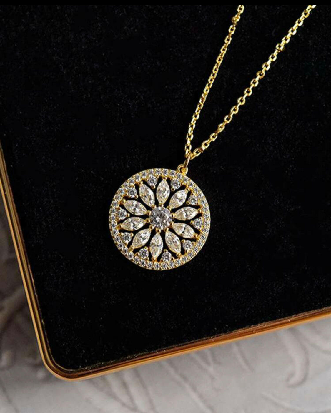 This stylish pendant necklace is crafted from gold-plated sterling silver and inlaid with sparkling cubic zirconia stones. The eye-catching sunflower design brings a hint of nature to your outfit. A perfect accessory for any special occasion.