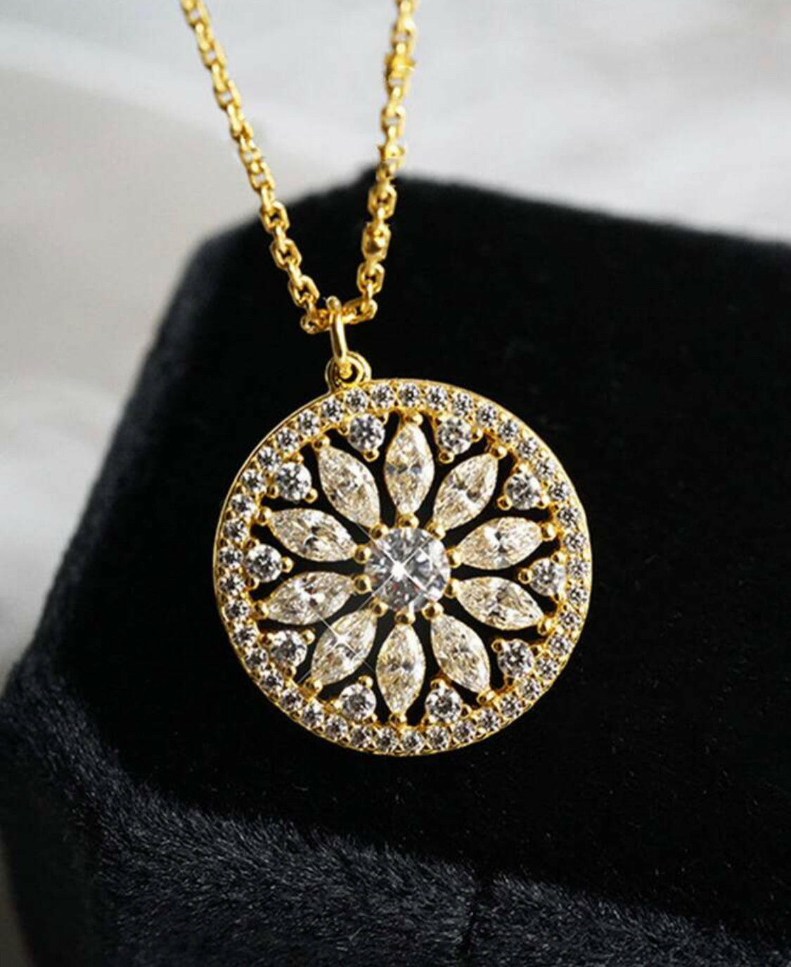 This stylish pendant necklace is crafted from gold-plated sterling silver and inlaid with sparkling cubic zirconia stones. The eye-catching sunflower design brings a hint of nature to your outfit. A perfect accessory for any special occasion.