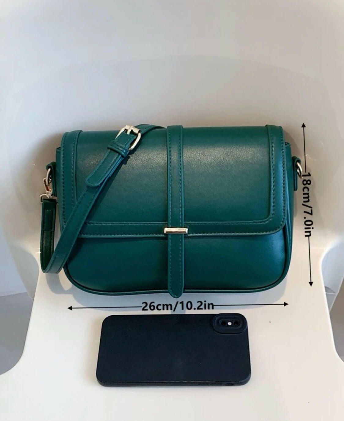 This eye-catching Green Metal Detail Flap Square Bag features a chic metallic trim and a contemporary square silhouette, making it the perfect addition to any wardrobe. The spacious interior is ideal for storing everyday items, and the hardware detail adds an edgy finishing touch.