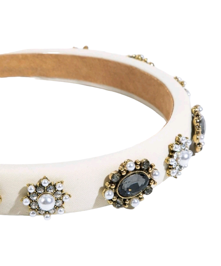 A glamorous headband adorned with beige cubic zirconia and faux pearl flowers, creating an opulent and stylish hair accessory.