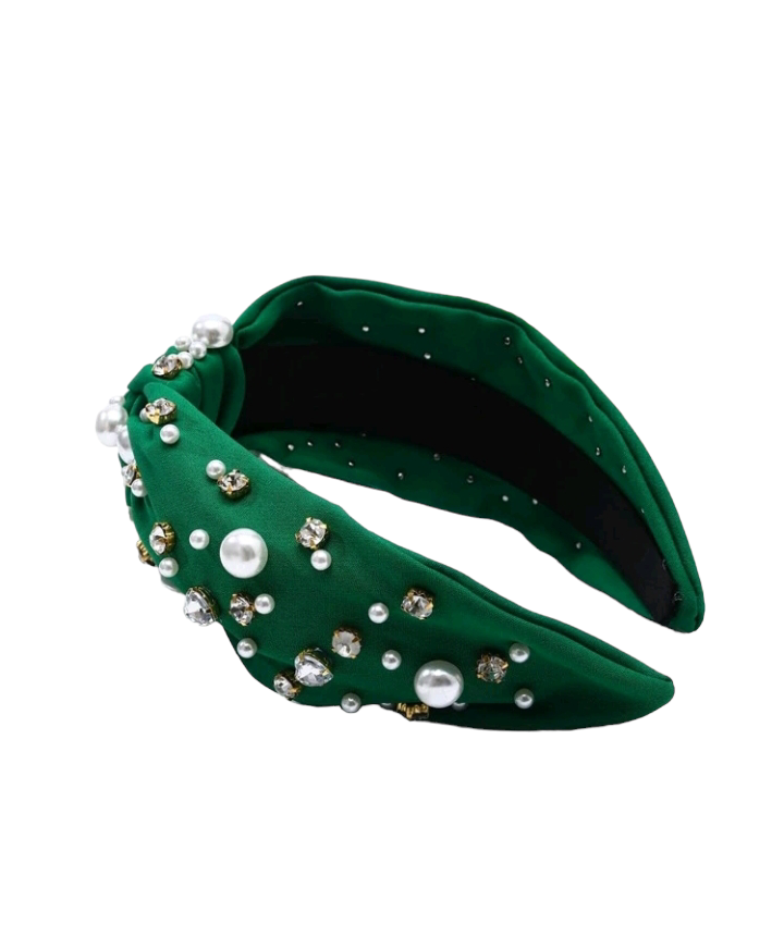 An olive green headband adorned with rhinestones and faux pearls, creating a chic and glamorous accessory. The headband is elegantly displayed, showcasing its intricate embellishments and stylish design.