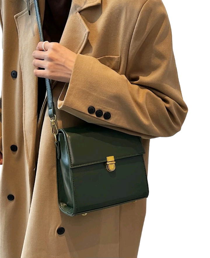 A dark green mini flap square bag with intricate stitch detailing. This compact bag has a square shape with a rich dark green hue. It showcases meticulous stitching on its surface and is designed as a stylish accessory for carrying small items or essentials with flair.