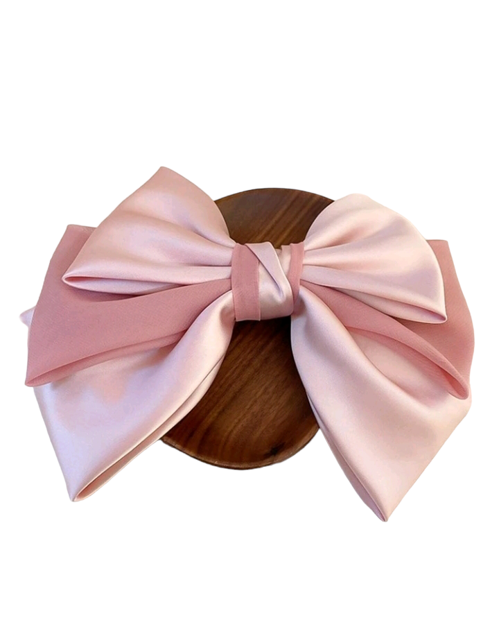 A fashionable pink hair clip embellished with a charming bow design. This delightful hair accessory adds a touch of style and whimsy to your look, making it a perfect choice for elevating your hairstyle with a playful and trendy accent.