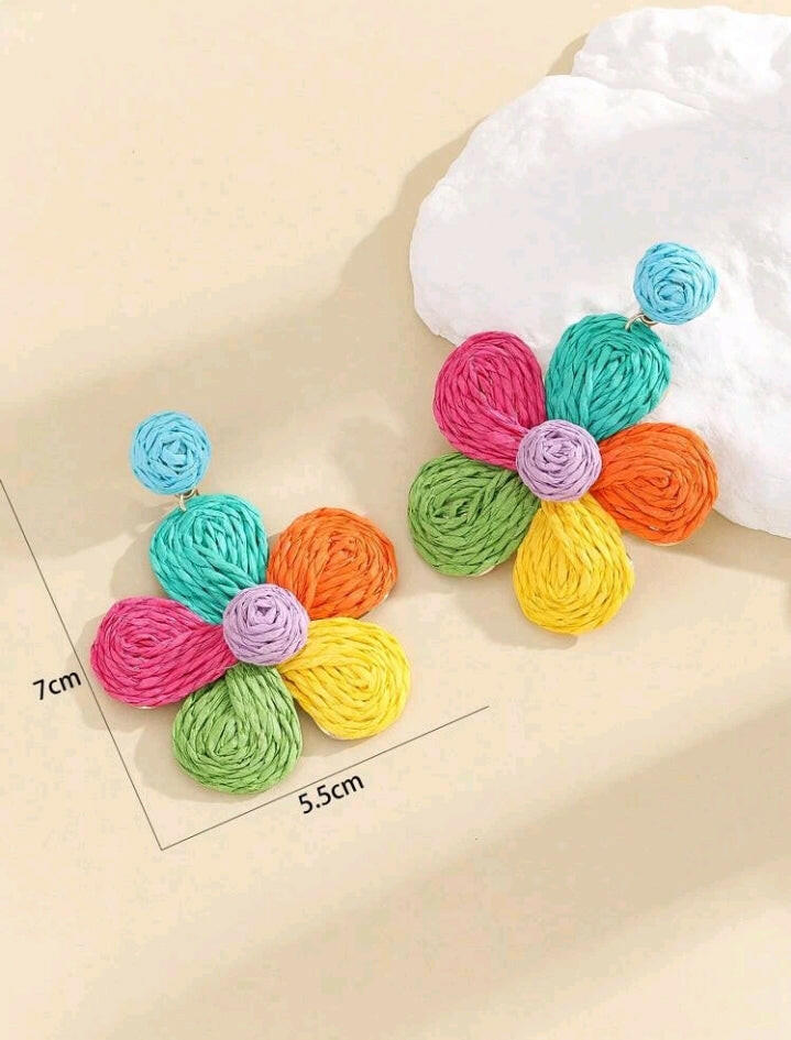 Close-up image of straw flower drop earrings, featuring delicate floral designs crafted from woven straw material, offering a lightweight and charming accessory choice.