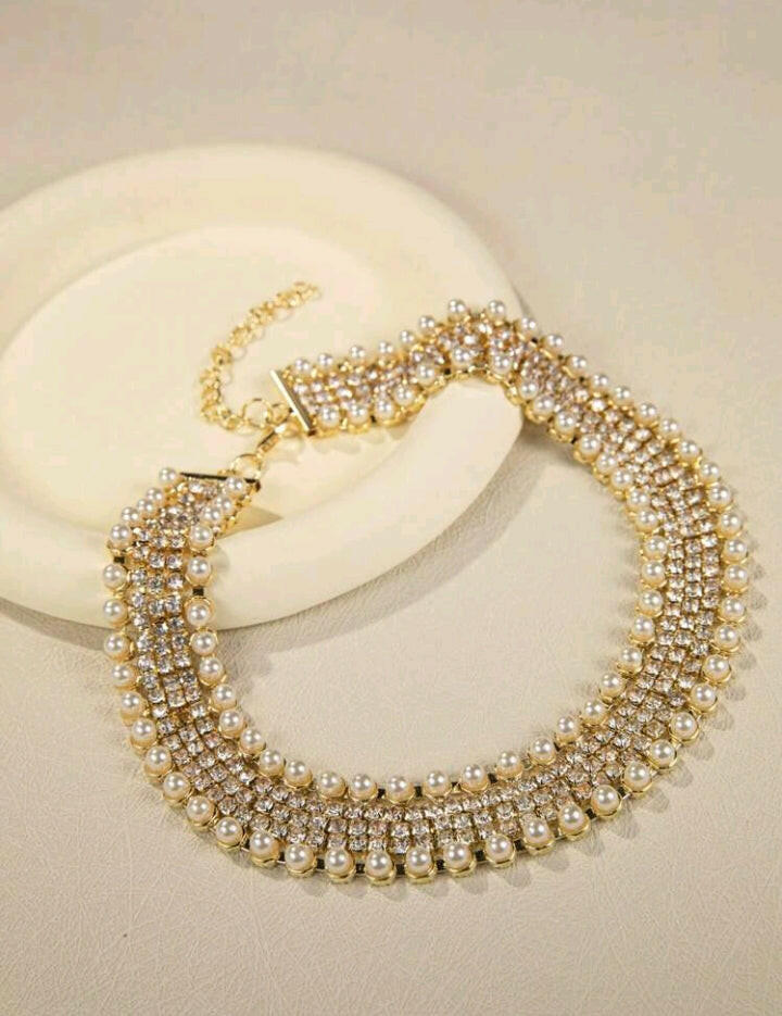 Glamorous rhinestone and faux pearl decorated necklace, featuring a dazzling combination of sparkling rhinestones and lustrous faux pearls. This exquisite necklace adds a touch of opulence and sophistication to any attire, making it a stunning statement piece for special occasions.