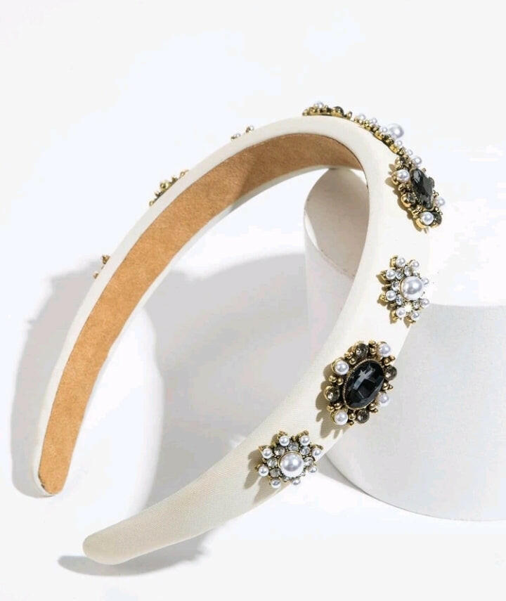 A glamorous headband adorned with beige cubic zirconia and faux pearl flowers, creating an opulent and stylish hair accessory.