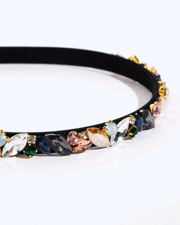 A sleek black headband embellished with shimmering cubic zirconia, adding a touch of elegance and sophistication to your hairstyle.