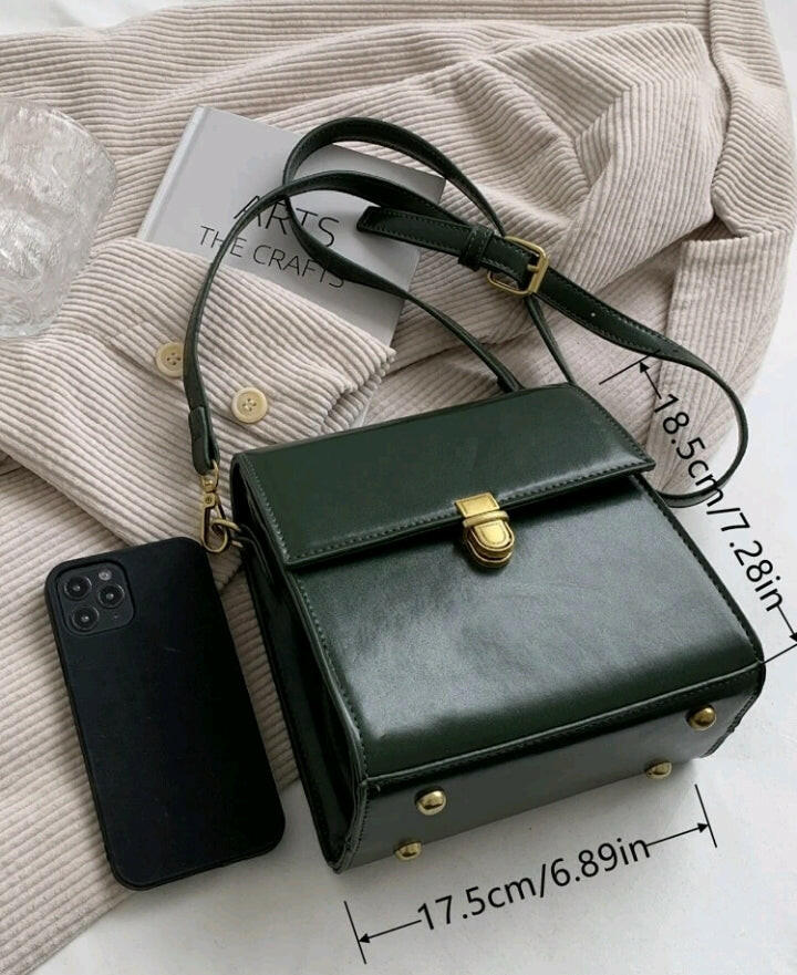A dark green mini flap square bag with intricate stitch detailing. This compact bag has a square shape with a rich dark green hue. It showcases meticulous stitching on its surface and is designed as a stylish accessory for carrying small items or essentials with flair.