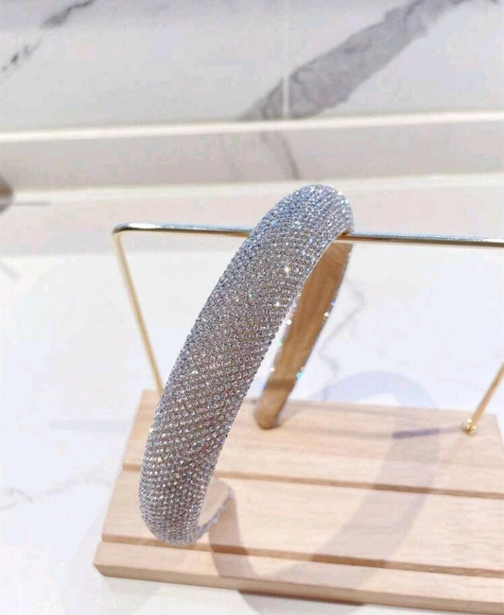 A glamorous wide headband in silver adorned with sparkling rhinestone decorations, elevating your hair accessory game with a touch of elegance and shine.