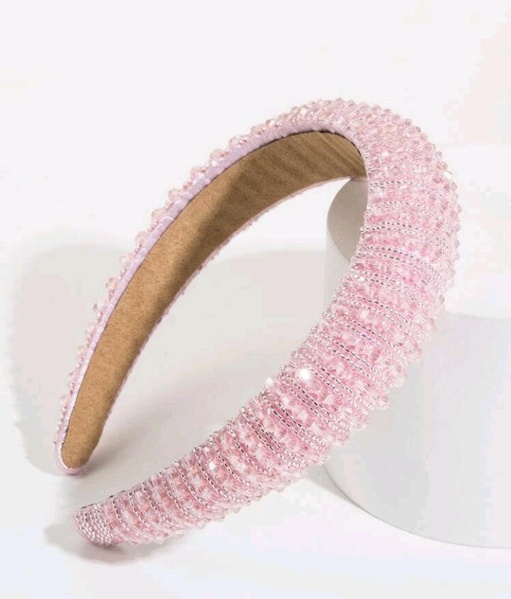 An opulent and elegant pink crystal decorative headband, designed with luxury style in mind. The headband features intricate crystal embellishments in various shades of pink, creating a stunning and glamorous accessory for any occasion.